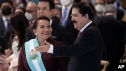 ARCHIVO - La presidenta Xiomara Castro sonríe luego de recibir la banda presidencial, mientras su esposo, el expresidente Manuel Zelaya, aplaude durante su toma de posesión como la primera mujer presidenta del país, en Tegucigalpa, Honduras, el 27 de enero de 2022.