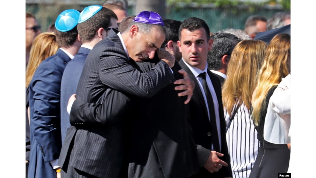 Mourners console each other at the gravesite for shooting victim Meadow Pollack in North Lauderdale, Florida, Feb. 16, 2018. Pollack was one of 17 victims killed in a shooting incident at Marjory Stoneman Douglas High School.