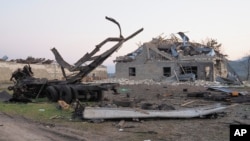 A destroyed building and vehicle after shelling by Azerbaijan's artillery during a military conflict outside Stepanakert, the separatist region of Nagorno-Karabakh, Oct. 19, 2020.