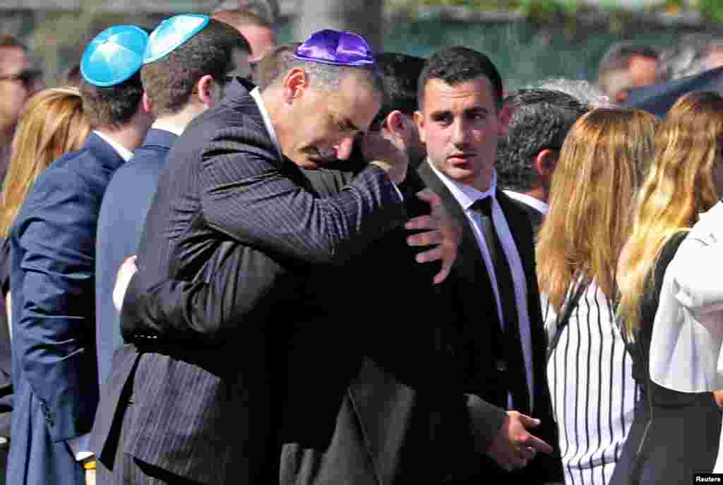 Mourners console each other at the gravesite for shooting victim Meadow Pollack in North Lauderdale, Florida, Feb. 16, 2018. Pollack was one of 17 victims killed in a shooting incident at Marjory Stoneman Douglas High School.