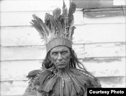 William Terrill Bradby, a Pamunkey Indian, in traditional dress and holding a club, sits for a portrait by the photographer De Lancey W. Gill in October 1899. BAE GN 00893 06197600, National Anthropological Archives, Smithsonian Institution