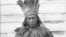 William Terrill Bradby, a Pamunkey Indian, in traditional dress and holding a club, sits for a portrait by the photographer De Lancey W. Gill in October 1899. BAE GN 00893 06197600, National Anthropological Archives, Smithsonian Institution