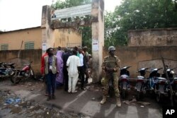 Security men stand guard in front of a polling station during the Presidential elections in Bamako, Mali, July 29, 2018.