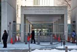 FILE - A security official walks in front of the entrance to the national headquarters of the Bureau of Alcohol, Tobacco, Firearms and Explosives in Washington, Jan. 23, 2014.