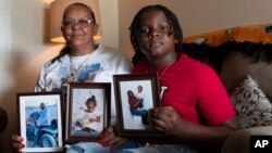 FILE - Charlene Roberts and her grandson Princeton Roberts, 11, pose with portraits of her son Kevin and daughter Jessie on Friday, Aug. 4, 2023, in Knoxville, Tenn. Roberts' son, Kevin, was killed in 2021 and her daughter, Jessie, in 2019. 