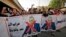 Iraqi demonstrators lift banners against Prime Minister Mustafa Al-Kadhimi during a protest rejecting last month's election result, near an entrance to the Green Zone in Baghdad, November 5, 2021.