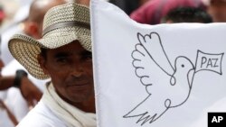 A rebel of the Revolutionary Armed Forces of Colombia, FARC, waves a white peace flag during an act to commemorate the completion of their disarmament process in Buenavista, Colombia, June 27, 2017.