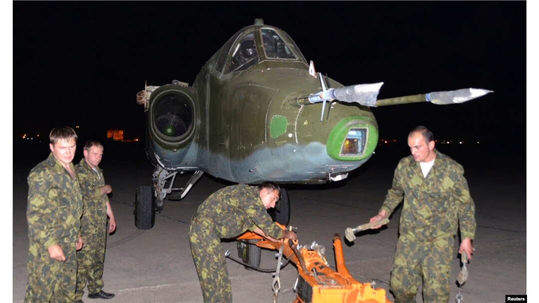 Russian soldiers unload a Russian Sukhoi SU-25 plane in al-Muthanna Iraqi military base at Baghdad airport in Baghdad, June 28, 2014.