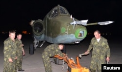 Russian soldiers unload a Russian Sukhoi SU-25 plane in al-Muthanna Iraqi military base at Baghdad airport in Baghdad, June 28, 2014.