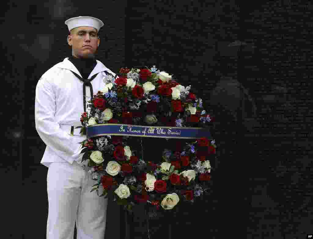 Američki mornar Kejleb arington u pratnji Sindi Mekejn, sekretara za odbranu Džima Matisa i šefa kabineta Bele kuće, Džona Kelija koji polažu venac kod spomenika Vijetnamskim veteranima u Vašingtonu. 1. septembar, 2018.