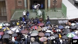Zimbabweans queue in the rain outside immigration offices in Johannesburg, Wednesday, Dec. 15, 2010, as they wait to apply to become legal immigrants before the cut-off deadline and what they fear will be a wave of deportations in the new year.