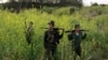 FILE - Rebel soldiers patrol near a military base in the Kokang region of Myanmar, March 10, 2015. 