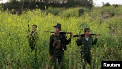 FILE - Rebel soldiers patrol near a military base in the Kokang region of Myanmar, March 10, 2015. 