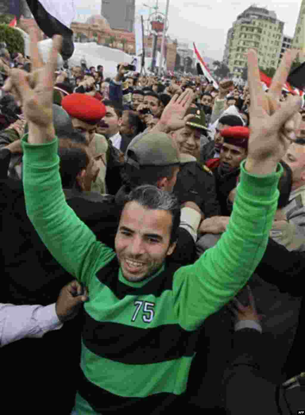 High-ranking Egyptian Army Gen. Hassan El-Rueni, above-center, waves as he is surrounded by congratulatory protesters as he moves through the crowd at the continuing anti-government demonstration in Tahrir Square in downtown Cairo, Egypt Thursday, Feb 10,