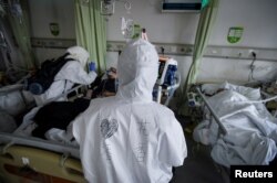 Medical workers in protective suits attend to coronavirus patients inside an isolated ward at a hospital in Wuhan, Hubei province, China Feb. 6, 2020.
