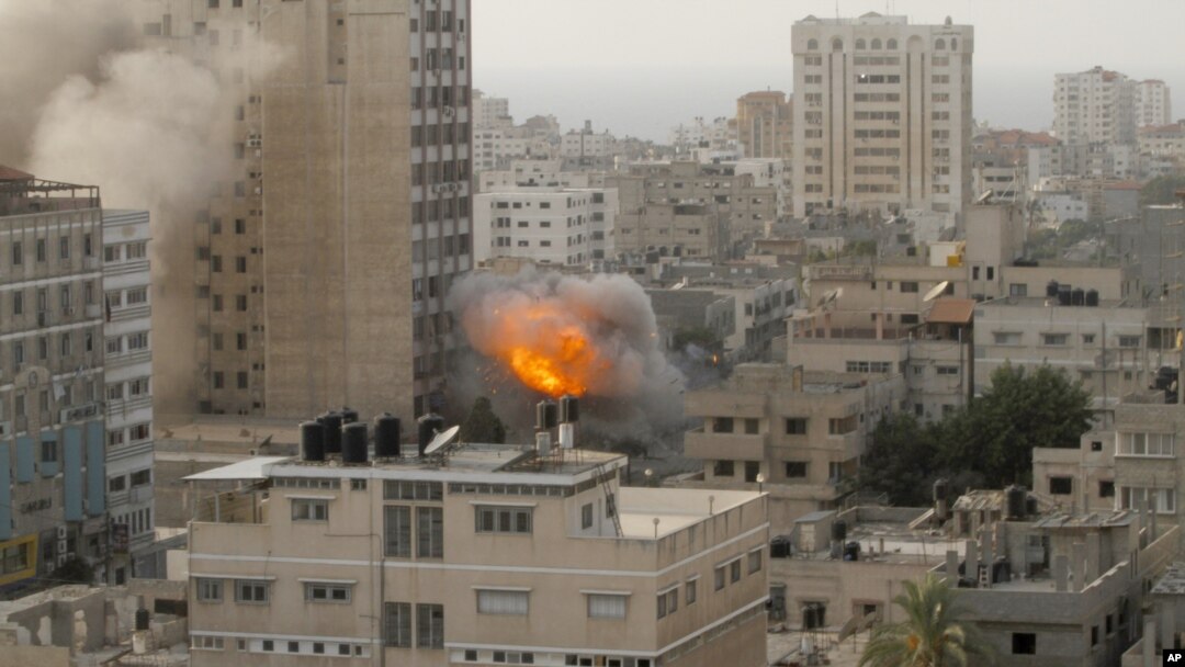 Asap dan kebakaran terlihat mengepul dari sebiah bangunan pencakar langit di kota Gaza (19/11). Serangan udara Israel atas wilayah ini sudah memasuki hari ke-6, sebagai upaya untuk menghentikan tembakan roket oleh kelompok Islamis Hamas.