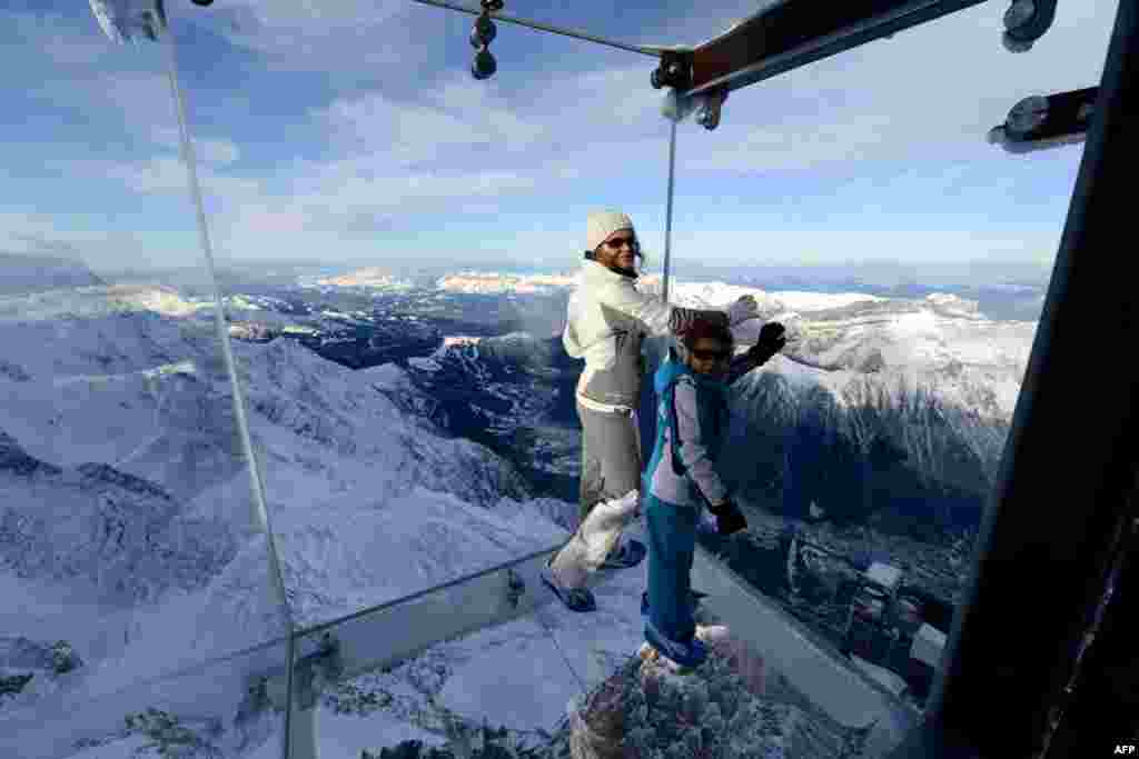 A woman and a child stand in the &quot;Step into the Void&quot; glass skywalk overlooking the French Alps on top of a 3842-meter peak in Chamonix. The installation, which opened to the public after three years of development, is made of three layers of glass and can withstand winds of up to 200kmph.