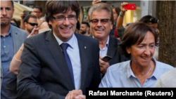 En la imagen, el destituido presidente catalán, Carles Puigdemont, saluda a una partidaria en Girona, el 28 de octubre de 2017.