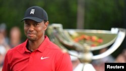 Tiger Woods memandang Piala FedEx setelah dia memenangkan turnamen golf Tour Championship di East Lake Golf Club, Atlanta, 23 September 2018.