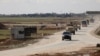 U.S. military vehicles move ahead of buses transporting Islamic State detainees from Syria to Iraq, according to a security source from the Syrian Democratic Forces, in Qamishli, Syria, February 8, 2026. 