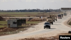 U.S. military vehicles move ahead of buses transporting Islamic State detainees from Syria to Iraq, according to a security source from the Syrian Democratic Forces, in Qamishli, Syria, February 8, 2026. 