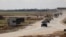 U.S. military vehicles move ahead of buses transporting Islamic State detainees from Syria to Iraq, according to a security source from the Syrian Democratic Forces, in Qamishli, Syria, February 8, 2026. 