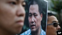 FILE - Anti-Beijing protesters, with a picture of human rights lawyer Pu Zhiqiang, protest outside the Chinese liaison office to demand Pu's release, in Hong Kong, Dec. 15, 2015. The United Nations human rights chief Zeid Ra'ad al-Hussein called on China on Feb. 16, 2016, to immediately and unconditionally release detained lawyers and activists.