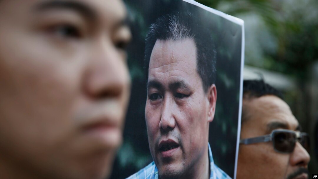 Demonstran anti-Beijing membawa foto pakar hukum hak asasi manusia, Pu Zhiqiang, protes di luar kantor liaison China menuntut pembmebasan Pu, di Hong Kong, Selasa, 15 Desember 2015.