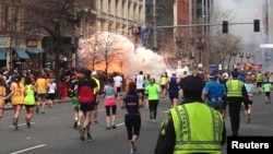 FILE- Runners continue to run towards the finish line of the Boston Marathon as an explosion erupts in this photo exclusively licensed to Reuters by photographer Dan Lampariello, in Boston, Massachusetts, April 15, 2013.