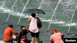 Tourists attempt to cool off at a fountain at the World War II Memorial on the National Mall during a heat wave, in Washington, July 21, 2019.