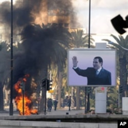 Smoke rises from fire left after clashes between security forces and demonstrators in Tunis, 14 Jan 2011