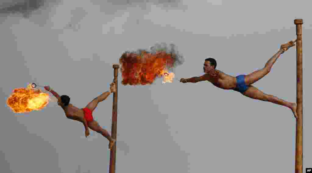 Indian army soldiers spit fire as they perform the mallakhamb, a traditional Indian gymnastic sport, during a display of skills at the Officers Training Academy in Chennai.