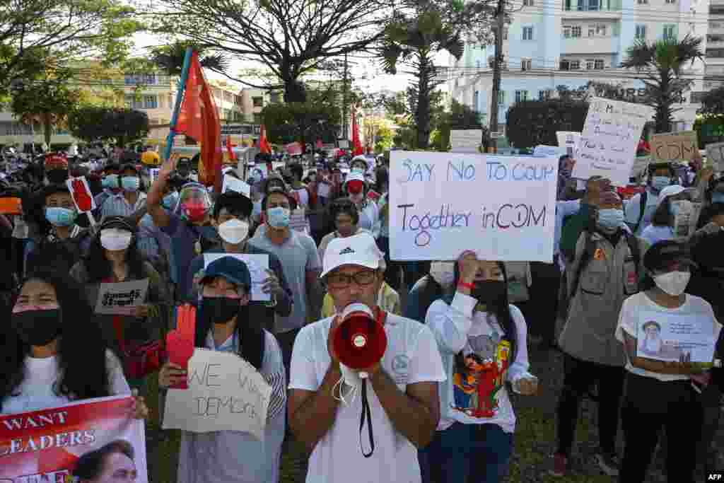 Protesters hold signs during a demonstration against the military coup in front of the Central Bank of Myanmar in Yangon on February 11, 2021. (Photo by Sai Aung MAIN / AFP)