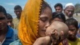 A Rohingya Muslim woman Hanida Begum, who crossed over from Myanmar into Bangladesh, kisses her infant son Abdul Masood who died when the boat they were traveling was capsized just before reaching the shore of the Bay of Bengal, in Shah Porir Dwip, Bangladesh.