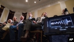 Audience members look at monitors displaying detected data which scientists say is proof of gravitational ripples, Thursday, Feb. 11, 2016, during a news conference at the National Press Club in Washington, just as Albert Einstein predicted a century ago.