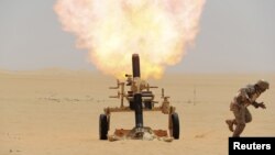 FILE - A Saudi soldier fires a mortar towards Houthi rebel positions, at the Saudi border with Yemen, April 21, 2015.