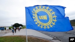 FILE - A United Auto Workers flag flies near strikers outside the General Motors Orion Assembly plant in Orion Township, Mich., Sept. 30, 2019.