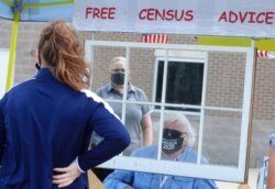 FILE - Amid concerns of the spread of COVID-19, census worker Ken Leonard wears a mask as he helps at a U.S. Census walk-up counting site set up for Hunt County in Greenville, Texas, July 31, 2020.