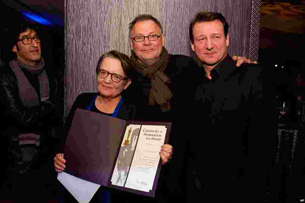 Agnieszka Holland, "In Darkness" (left), accepts her certificate of nomination for the 84th Academy Awards from Janusz Kaminski (center) at a Foreign Language Film Award reception held in the Grand Lobby of the Samuel Goldwyn Theater in Beverly Hills, CA 