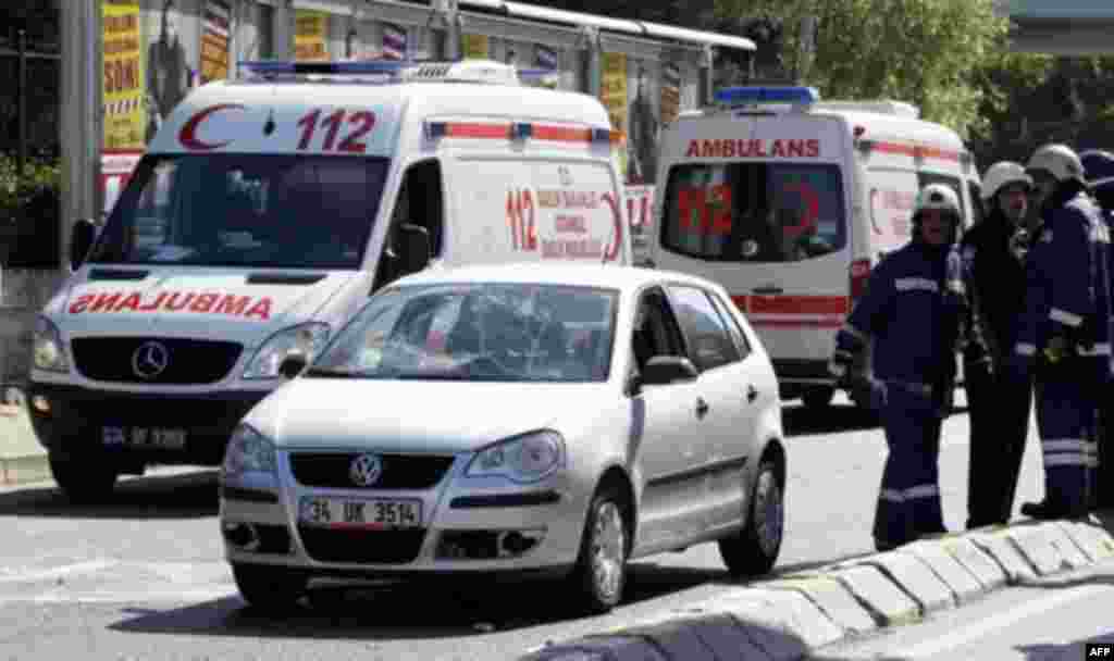 Firemen stand next to a damaged car following a blast in Istanbul May 26, 2011. A bicycle bomb wounded seven people including a police officer in Istanbul on Thursday, Istanbul's police chief Huseyin Capkin told reporters. He said none of the wounded were