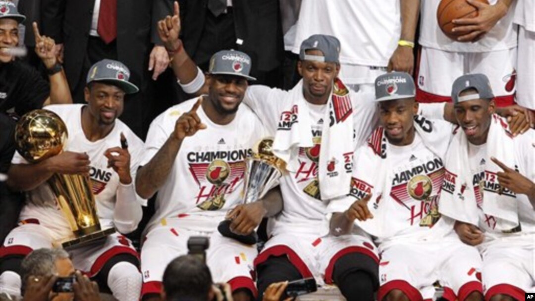 Tim Miami Heat berpose bersama, sesaat setelah berhasil memenangkan Kejuaraan Liga NBA (22/6). Dwyane Wade (kiri) memegang Piala NBA "Larry O'Brien" dan LeBron James (dua dari kiri) memegang pialanya sebagai pemain terbaik NBA tahun ini.