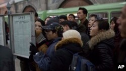 13일 평양 기차역에 장성택 전 국방위 부위원장의 처형 소식이 게재된 가운데, 북한 주민들이 기차역에 게재된 신문을 읽고 있다.