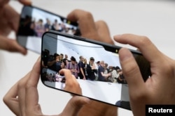 Attendees try the new iPhone 16 as Apple holds an event at the Steve Jobs Theater on its campus in Cupertino, California, on Sept. 9, 2024.