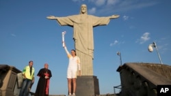 Brazil's former volleyball player Isabel Barroso Salgado carries the Olympic torch in front of the Christ the Redeemer statue on its way for the opening ceremony of Rio's 2016 Summer Olympics in Rio de Janeiro, Brazil, Aug. 5, 2016. 