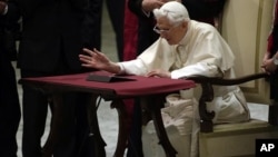 Pope Benedict XVI watches a tablet at the Vatican, in Rome, December 12, 2012.