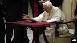Pope Benedict XVI watches a tablet at the Vatican, in Rome, December 12, 2012.