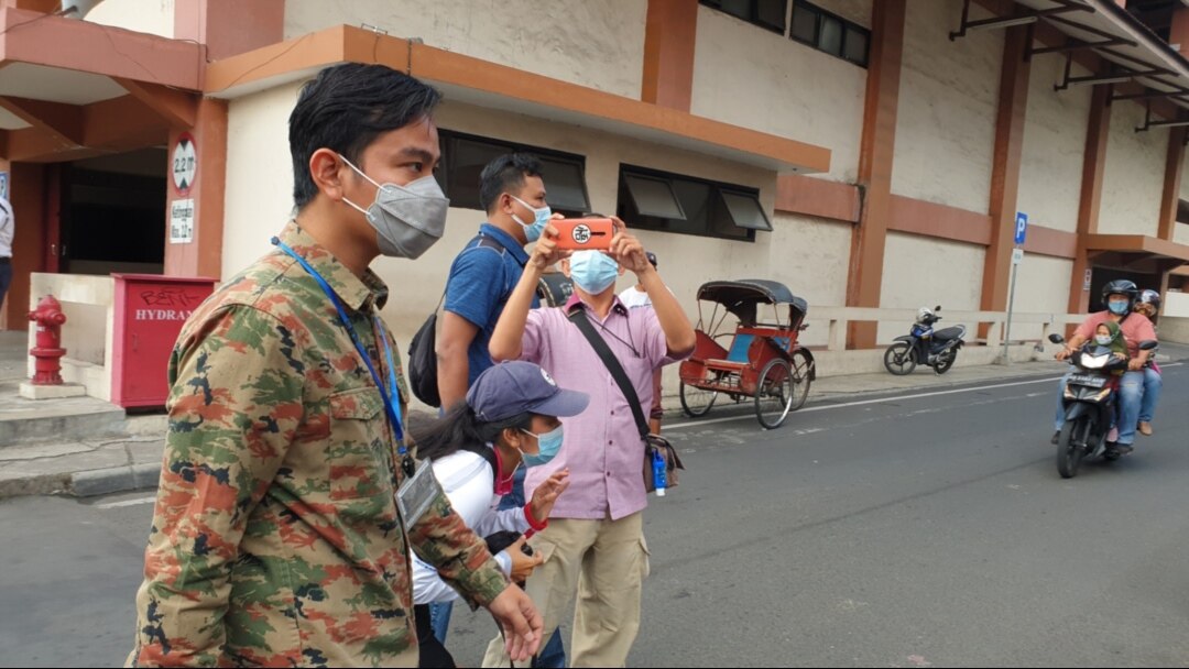 Wali Kota Solo Gibran Rakabuming Raka (kiri) berjalan di sekitar Pasar Klewer Solo untuk mengembalikan uang hasil pungli yang dilakukan lurah setempat dan meminta maaf pada ratusan warga korban pungli, Minggu (2/5). (Foto: VOA/ Yudha Satriawan)