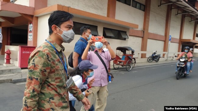 Wali Kota Solo Gibran Rakabuming Raka (kiri) berjalan di sekitar Pasar Klewer Solo untuk mengembalikan uang hasil pungli yang dilakukan lurah setempat dan meminta maaf pada ratusan warga korban pungli, Minggu (2/5). (Foto: VOA/ Yudha Satriawan)