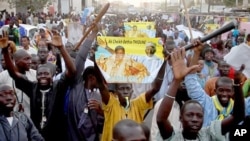 Disciples of Cheikh Béthio Thioune chant and carry clubs on a marchon March 17, 2012 in Dakar in support of President Abdoulaye Wade. They say the clubs were for self defense against anti-Wade activists.