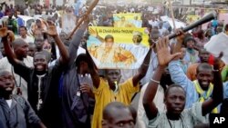 Les disciples de Cheikh Béthio Thioune chantent et portent les clubs sur un marchon le 17 mars 2012 à Dakar en soutien au président Abdoulaye Wade.